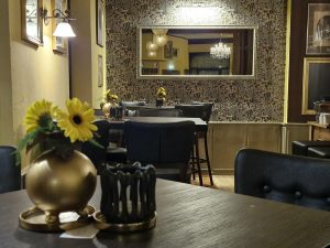 goldene-keramikvasen-tischdeko-sonnenblumen-eichentische-gastronomie-design-rosali
